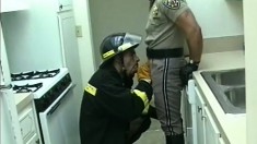 Nasty fire-fighter shoves his dirty cock in the mouth of police officer